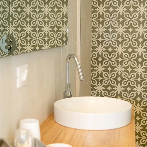 Bagno con lavabo bianco e piastrelle verdi