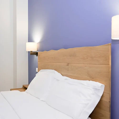Camera con parete blu e testata in legno